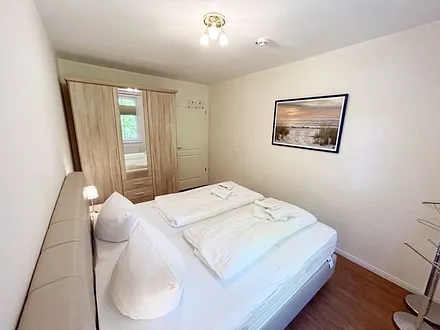 Schlafzimmer mit einem Boxspringbett (1,80 m x 2,00 m), Ablagefläche, Kleiderschrank und Insektenschutzgitter