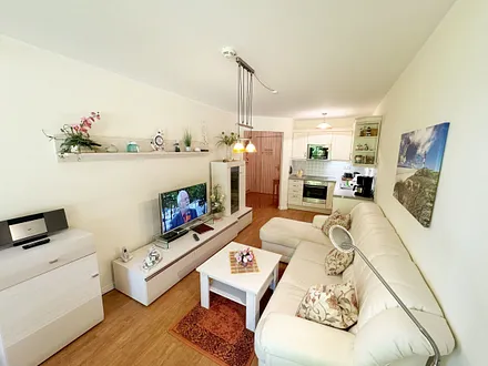 Wohnbereich mit gemütlicher Couch, Leselampe, Smart-TV, DVD-Player und Radio mit CD