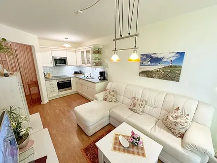 Wohnbereich mit gemütlicher Couch, Leselampe, Smart-TV, DVD-Player und Radio mit CD