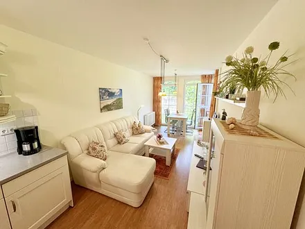 Wohnbereich mit gemütlicher Couch, Leselampe, Smart-TV, DVD-Player und Radio mit CD