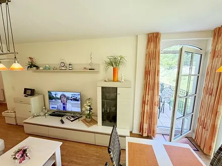 Wohnbereich mit gemütlicher Couch, Leselampe, Smart-TV, DVD-Player und Radio mit CD