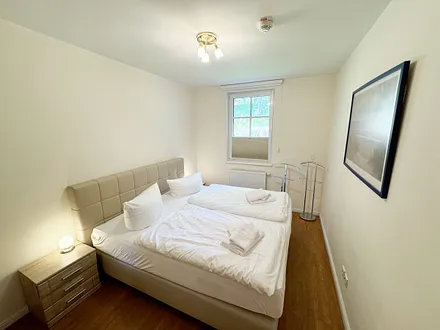 Schlafzimmer mit einem Boxspringbett (1,80 m x 2,00 m), Ablagefläche, Kleiderschrank und Insektenschutzgitter