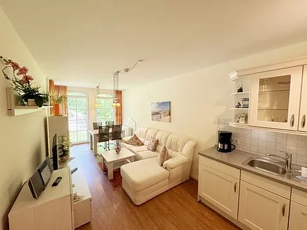 Wohnbereich mit gemütlicher Couch, Leselampe, Smart-TV, DVD-Player und Radio mit CD