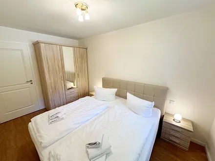 Schlafzimmer mit einem Boxspringbett (1,80 m x 2,00 m), Ablagefläche, Kleiderschrank und Insektenschutzgitter