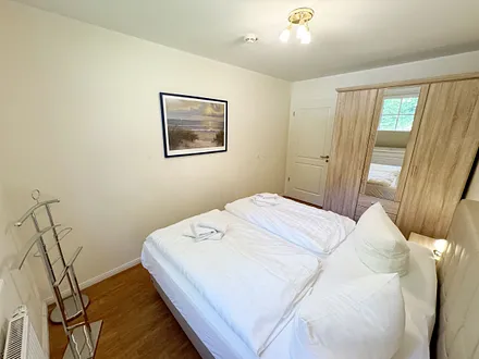 Schlafzimmer mit einem Boxspringbett (1,80 m x 2,00 m), Ablagefläche, Kleiderschrank und Insektenschutzgitter