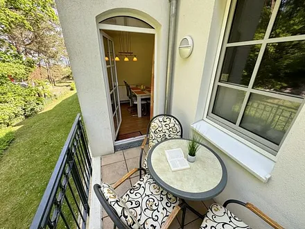 bestuhlter Balkon mit Blickrichtung zu Kiefern und Dünen