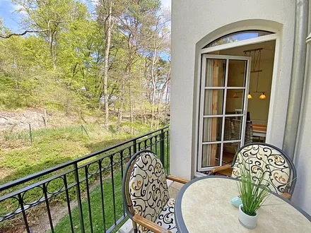 bestuhlter Balkon mit Blickrichtung zu Kiefern und Dünen