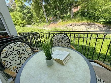 bestuhlter Balkon mit Blickrichtung zu Kiefern und Dünen