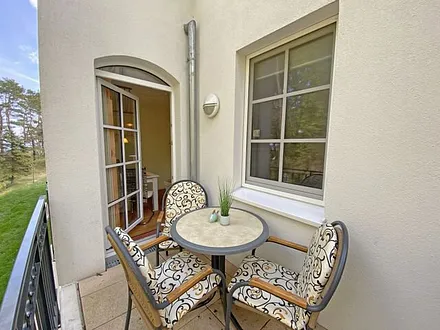 bestuhlter Balkon mit Blickrichtung zu Kiefern und Dünen