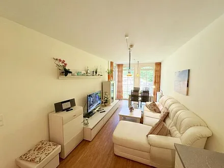 Wohnbereich mit gemütlicher Couch, Leselampe, Smart-TV, DVD-Player und Radio mit CD