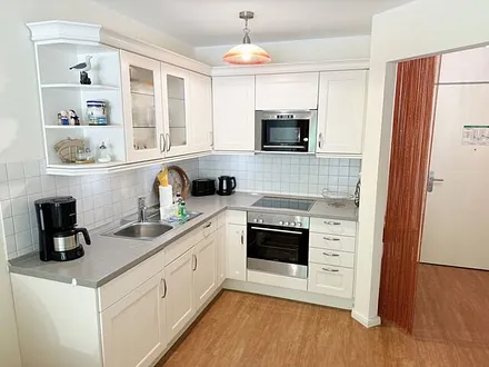 Küchenzeile mit Mikrowelle, Backofen, Ceranfeld, Spülmaschine, Kühlschrank mit Gefrierfach, Kaffeemaschine und praktischen Helfern