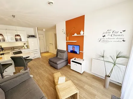 Wohnbereich mit gemütlicher Couch, LED-TV und DVD-Player 