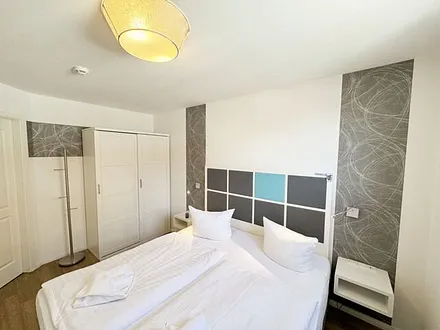 Schlafzimmer mit Boxspringbett (1,80 m x 2,00 m), Nachttischkonsolen, Kleiderschrank und LED-TV