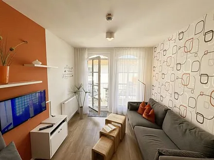 Wohnbereich mit gemütlicher Couch, LED-TV und DVD-Player 