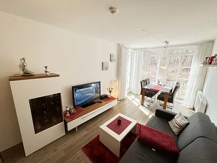 Wohnbereich mit gemütlicher Couch, heller Anrichte, Flachbild TV, DVD-Player und eine CD-Musikanlage