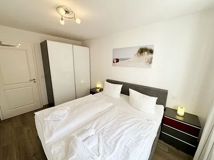 Schlafzimmer mit komfortablen Boxspringbett (1,80 m x 2,00 m), hochwertige durchgehende Matratze, Nachttischkonsolen, 2-trg. Kleiderschrank und TV