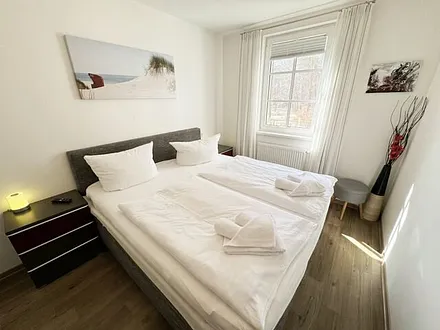 Schlafzimmer mit komfortablen Boxspringbett (1,80 m x 2,00 m), hochwertige durchgehende Matratze, Nachttischkonsolen, 2-trg. Kleiderschrank und TV