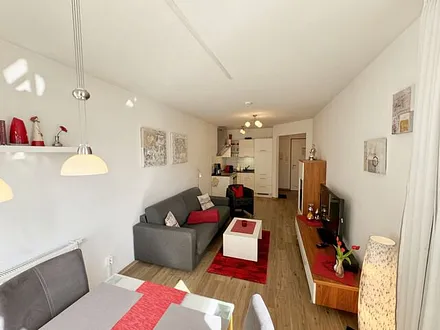 Wohnbereich mit gemütlicher Couch, heller Anrichte, Flachbild TV, DVD-Player und eine CD-Musikanlage