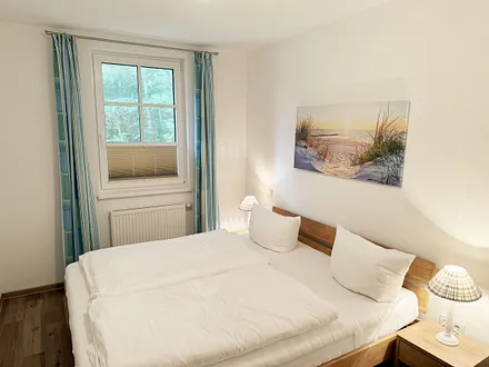 Schlafzimmer mit Doppelbett (1,80 m x 2,00 m), Nachttischkonsolen, Kleiderschrank, Fliegenschutzgitter und Verdunklungsplissees 