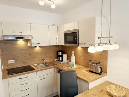 integrierte Küchenzeile mit Mikrowelle und Grillfunktion, Ceranfeld, Abzugshaube, Spülmaschine, Kühlschrank mit Gefrierfach, Kaffeemaschine und anderen praktischen Helfern