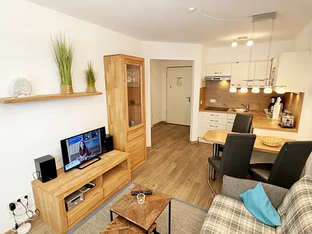 Wohnbereich mit gemütlicher Couch (Aufbettung für die 3. Person 1,30 m x 1,95 m), Sessel, Couchtisch, Leselampe, kleine Anrichte mit LCD-TV sowie ein Radio mit CD 