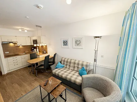 Wohnbereich mit gemütlicher Couch (Aufbettung für die 3. Person 1,30 m x 1,95 m), Sessel, Couchtisch, Leselampe, kleine Anrichte mit LCD-TV sowie ein Radio mit CD 