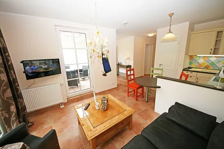 liebevoll eingerichteter Wohnbereich mit Couch, Flachbild-TV sowie Radio mit CD-Player