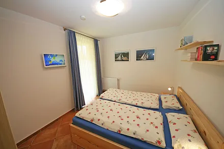 Schlafzimmer mit Doppelbett und TV
