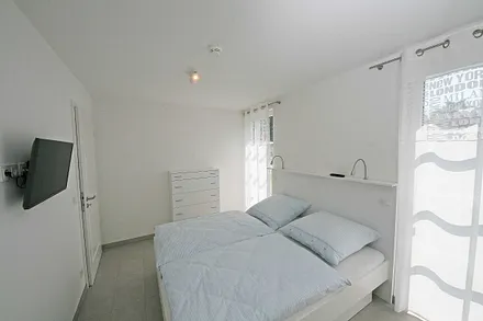 Schlafzimmer mit Doppelbett (1,80 m x 2,00 m), Flachbild TV und einem Kleiderschrank