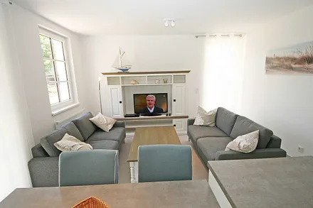 Wohnbereich mit 2 Couchen, Leselampe, Smart-TV, Blu-Ray-Player und eine Musikanlage mit DAB-Radio