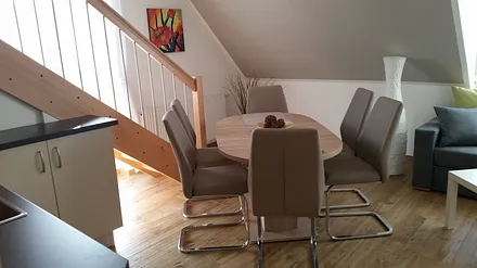 Wohnzimmer mit offener Küche und Essecke, sowie Schlafcouch