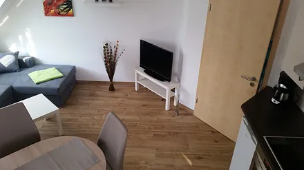 Wohnzimmer mit offener Küche und Essecke, sowie Schlafcouch