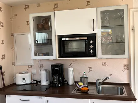 Gut ausgestattete Küche mit Kühlschrank, Minibackofen, Kaffeemaschine und vielem mehr