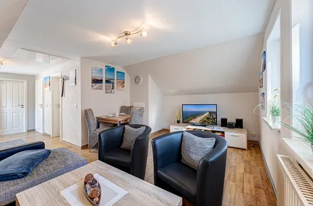 Wohnzimmer mit Couch, Flat-TV, Essplatz