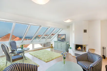 Das große Wohnzimmer hat einen Kamin (mit Holz beheizbar) und schaut über die erste Reihe auf Meer und Seebrücke.