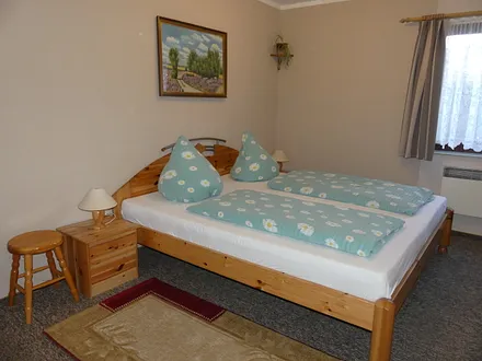 Schlafraum mit Doppelbett und einem Etagenbett