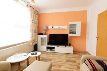 Wohnzimmer mit Wohnkombination und Flachbild-TV