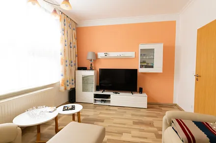 Wohnzimmer mit Wohnkombination und Flachbild-TV