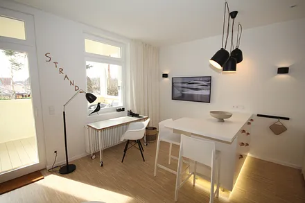 Wohnzimmerecke mit Schreibtisch und Zugang zum Balkon