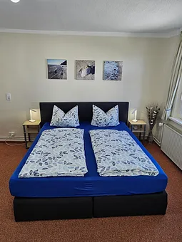 Boxspringbett mit einer Liegefläche von 140x200 cm, mit Nachttisch  und LED-Leselampe,  das Fenster kann verdunkelt werden 