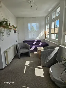 Veranda ausgestattet mit 2 Clubsessel, Couch, Sitzkissen, Tisch und großem TV-Gerät