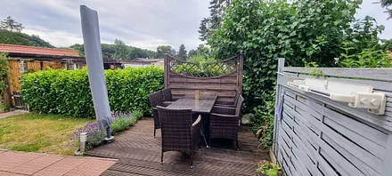 Die Terrasse mit Tisch und 6 Stühlen