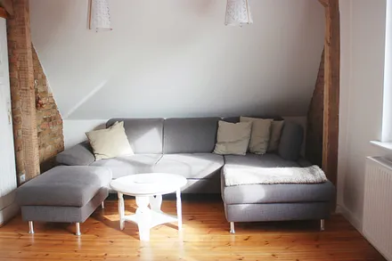 geräumiges Wohnzimmer mit bequemer Sitzecke und Treppe zur offenen Galerie im Spitzdach (Schlafplatz für 3. und 4. Person)