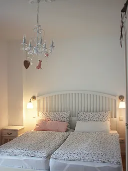 Schlafzimmer mit großem Doppelbett, TV und Zugang zur Terrasse
