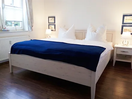 Das Schlafzimmer hat Doppelbett, Kleiderschrank, ein 2. TV-Gerät und einen Außenrolladen am Fenster.