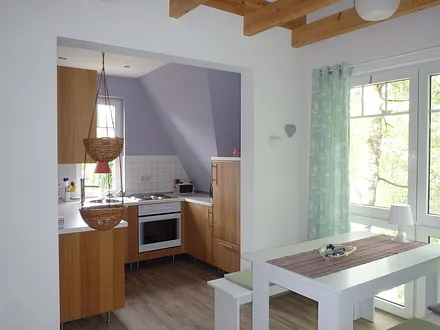 Essbereich und offene Küche mit Kühlschrank, Herd, Backofen, Geschirrspüler, Caffissimo-Maschine 