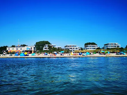 Die Ferienwohnungsanlage Südkap mit DLRG Station vom Wasser aus.