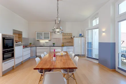 Küche mit Essbereich und angrenzendem Balkon