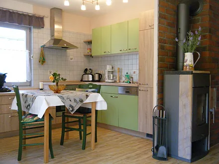 Offene Küche mit Esstisch und Kamin zum Wohnbereich gerichtet