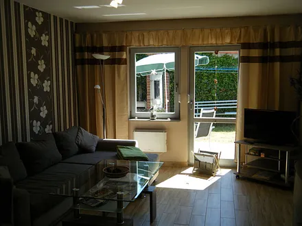 Wohnraum mit TV und Zugang zur Terrasse